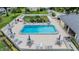 Aerial view of the community pool with ample lounge chairs and tables under blue umbrellas at 2465 Northside Dr # 605, Clearwater, FL 33761