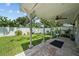 Backyard with brick paved patio area and covered area with fan, surrounded by lush landscaping at 2811 W Sitios St, Tampa, FL 33629