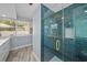 Stylish bathroom with a glass-enclosed shower with blue subway tile and gold hardware at 2811 W Sitios St, Tampa, FL 33629