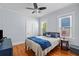 Cozy bedroom featuring hardwood floors, windows with blinds, and a ceiling fan at 2811 W Sitios St, Tampa, FL 33629