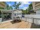 Deck featuring outdoor seating, a white fence, garage and lush green landscaping creates a private oasis at 2811 W Sitios St, Tampa, FL 33629