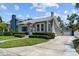 Street view of a home with a well-manicured lawn, an American flag, a detached garage and a private driveway at 2811 W Sitios St, Tampa, FL 33629