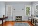 Bright living room featuring hardwood floors, white fireplace, two windows, and stylish furniture at 2811 W Sitios St, Tampa, FL 33629