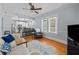 Open-concept living room with hardwood floors, a ceiling fan, and a clear view to the bright kitchen at 2811 W Sitios St, Tampa, FL 33629