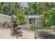 Backyard view of the pond and seating area surrounded by lush greenery and palm trees at 2820 Whitney Rd, Clearwater, FL 33760