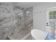 Bathroom featuring a glass shower with marble tiling, rainfall shower head and freestanding tub at 2820 Whitney Rd, Clearwater, FL 33760