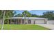 Charming single-story home with lush green lawn, metal roof, and inviting front porch with porch swing at 2820 Whitney Rd, Clearwater, FL 33760