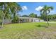 Landscaped front yard with freshly mowed grass featuring a charming one-story home, white picket fence, and blue accents at 2820 Whitney Rd, Clearwater, FL 33760