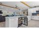 Open kitchen with an island cooktop, white cabinets, and a wine cooler at 2820 Whitney Rd, Clearwater, FL 33760