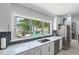 Kitchen sink features a marble countertop with view overlooking the pool with waterfall feature at 2820 Whitney Rd, Clearwater, FL 33760