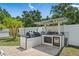 Outdoor kitchen with grill, sink, beverage cooler, and white privacy fence at 2820 Whitney Rd, Clearwater, FL 33760