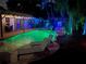 Backyard swimming pool with a stacked stone waterfall and lounge chairs, lit up at night at 2820 Whitney Rd, Clearwater, FL 33760