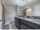 Well-lit bathroom featuring double sinks, granite countertops, dark cabinets, and a large mirror at 28504 Tranquil Lake Cir, Wesley Chapel, FL 33543