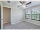 Well-lit bedroom with a ceiling fan, two windows for natural light, and a neutral color palette at 28504 Tranquil Lake Cir, Wesley Chapel, FL 33543