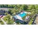 Aerial view of community pool and clubhouse surrounded by tropical landscaping and lush greenery at 28504 Tranquil Lake Cir, Wesley Chapel, FL 33543