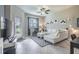 Bright living room with tile flooring, neutral decor, ceiling fan, and a view to the backyard at 28504 Tranquil Lake Cir, Wesley Chapel, FL 33543