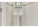 Elegant pedestal sink and decorative mirror create a charming powder room at 2885 Deer Pine Trl, Land O Lakes, FL 34638