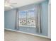 Serene bedroom with a window view, light blue walls, and sleek flooring at 2885 Deer Pine Trl, Land O Lakes, FL 34638