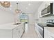 Galley kitchen featuring stainless appliances, white cabinets, quartz countertops, pendant lighting, and an open layout at 2885 Deer Pine Trl, Land O Lakes, FL 34638