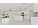 Bright, open-concept kitchen featuring white cabinetry, stainless steel appliances, and a large island with pendant lighting at 2885 Deer Pine Trl, Land O Lakes, FL 34638