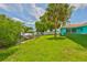 Backyard view features a grassy lawn with canal and boat dock access, perfect for waterfront living and enjoying Florida's outdoors at 301 Carlyle Blvd, Ruskin, FL 33570