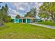 Charming one-story home featuring a covered carport, screened-in porch, and lush landscaping at 301 Carlyle Blvd, Ruskin, FL 33570