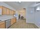 Open kitchen with light wood cabinetry and stainless appliances overlooks dining area at 301 Carlyle Blvd, Ruskin, FL 33570