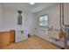 Bright laundry room with tile floors, utility sink, water heater, and ample storage space at 301 Carlyle Blvd, Ruskin, FL 33570