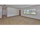 Bright living room featuring wood-look flooring and a large window overlooking the neighborhood at 301 Carlyle Blvd, Ruskin, FL 33570