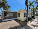 Charming backyard with brick-paved walkway, gravel groundcover, screened lanai, and mature palm trees at 3014 58Th S St, Gulfport, FL 33707