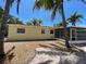 Charming backyard with brick-paved walkway, gravel groundcover, and a screened lanai surrounded by lush palm trees at 3014 58Th S St, Gulfport, FL 33707