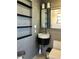 Modern bathroom showing updated floating sink, toilet, open shelving, and gray tiled walls at 3014 58Th S St, Gulfport, FL 33707