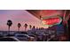Omaddy's neon sign at sunset by the waterfront. Restaurant is near a parking lot and waterfront at 3014 58Th S St, Gulfport, FL 33707