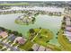 Aerial view of waterfront homes on a lake featuring a community park with walking paths at 31244 Baclan Dr, Wesley Chapel, FL 33545