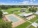 Aerial view of community park showcasing tennis court, playground, picnic areas, and green spaces for leisure activities at 31244 Baclan Dr, Wesley Chapel, FL 33545