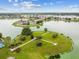 Community aerial view showcasing a lakeside park with walking paths and lush trees at 31244 Baclan Dr, Wesley Chapel, FL 33545