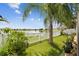 Inviting backyard featuring a white fence, lush landscaping, and a serene lake view at 31244 Baclan Dr, Wesley Chapel, FL 33545