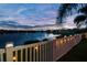 Tranquil backyard view of a lake and fence at dusk at 31244 Baclan Dr, Wesley Chapel, FL 33545