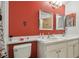 Bathroom featuring double sinks, white cabinets, tile flooring, and red accent wall at 31244 Baclan Dr, Wesley Chapel, FL 33545