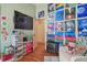 Bright bedroom with laminate floors, a wall of artwork, and a large wall-mounted television at 31244 Baclan Dr, Wesley Chapel, FL 33545