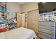Bedroom with closet, laminate floors, a dresser, and an open door with butterfly decor at 31244 Baclan Dr, Wesley Chapel, FL 33545