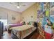 A shared bedroom with two beds, laminate floors, ceiling fan and a whimsical poster collage wall at 31244 Baclan Dr, Wesley Chapel, FL 33545