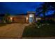 Night view of single-story home featuring a well-maintained lawn and an attached two-car garage at 31244 Baclan Dr, Wesley Chapel, FL 33545