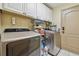Well-equipped laundry room with ample storage cabinets, modern washer and dryer, and access to the exterior at 31244 Baclan Dr, Wesley Chapel, FL 33545