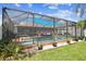 Enclosed swimming pool and spa with brick detailing and well-manicured landscaping at 31244 Baclan Dr, Wesley Chapel, FL 33545