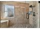 Updated tiled shower featuring a glass enclosure, bench seating, and decorative pebble accents at 31244 Baclan Dr, Wesley Chapel, FL 33545