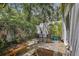 Private outdoor patio with a seating area, lush greenery, and shade at 325 5Th S Ave # 9, St Petersburg, FL 33701
