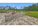 Outdoor patio and firepit area, with seating, overlooking a tranquil pond and lush green lawn at 33668 Willow Point Ct, Wesley Chapel, FL 33545