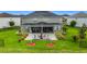 Aerial of a well-manicured backyard, featuring a stone patio, fire pit and lush lawn at 33668 Willow Point Ct, Wesley Chapel, FL 33545