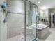 Features glass-enclosed shower and soaking tub with decorative tile surround and granite vanity at 33668 Willow Point Ct, Wesley Chapel, FL 33545